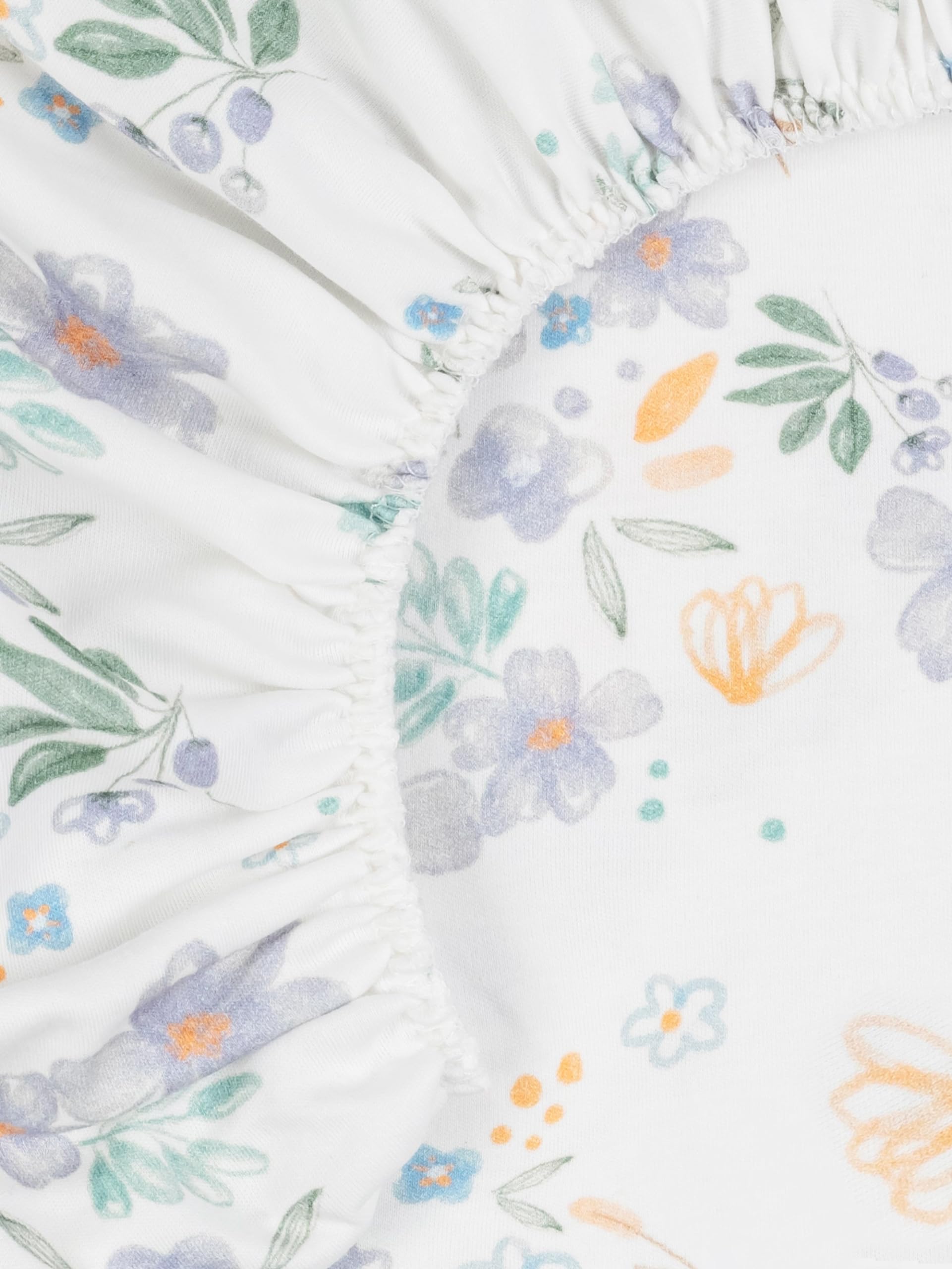 Under The Nile Daisy sheet on bassinet, breathable muslin fabric for year-round use.