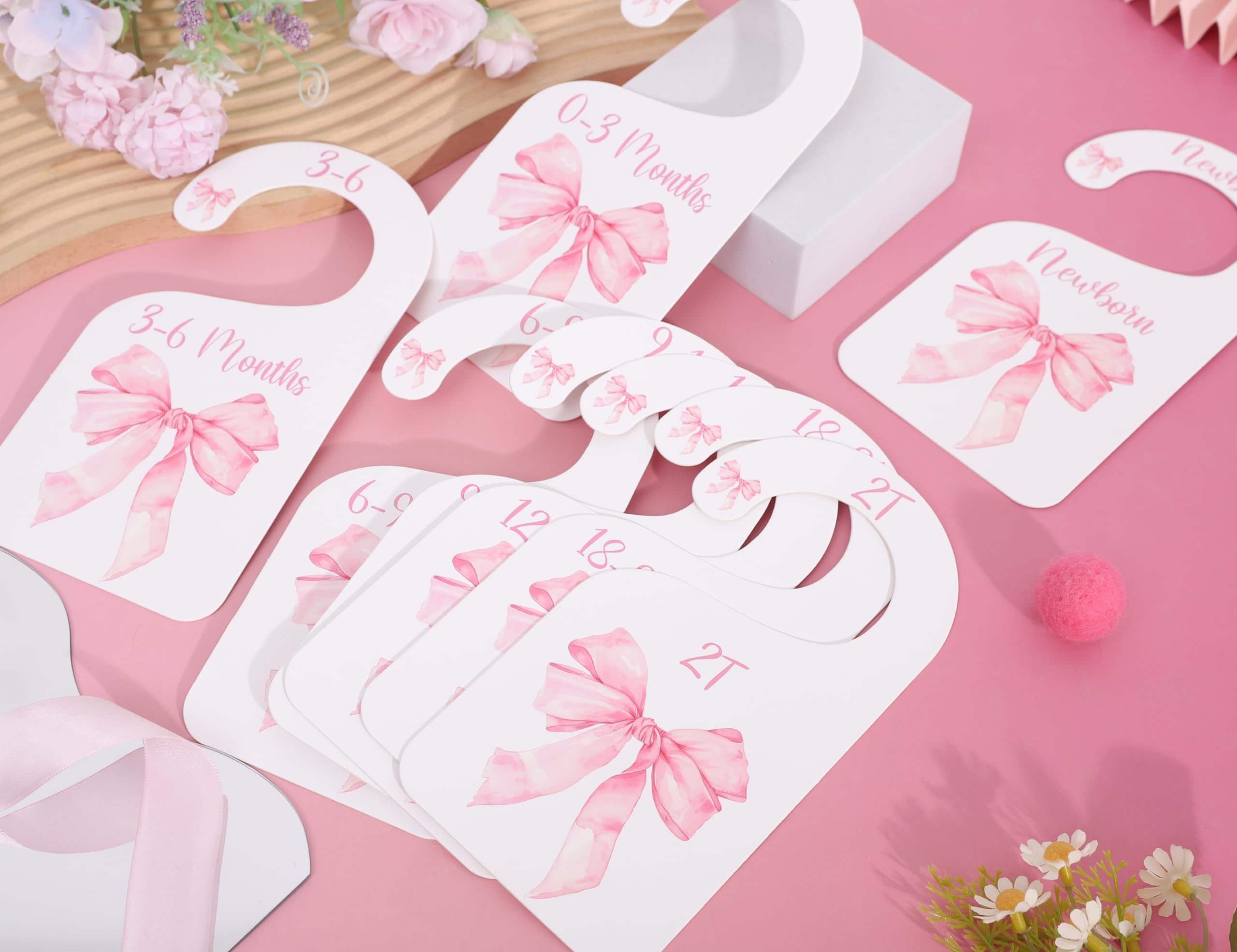 UOAOU bow-nursery-closet-divider-pink shown with hangers for easy organization.