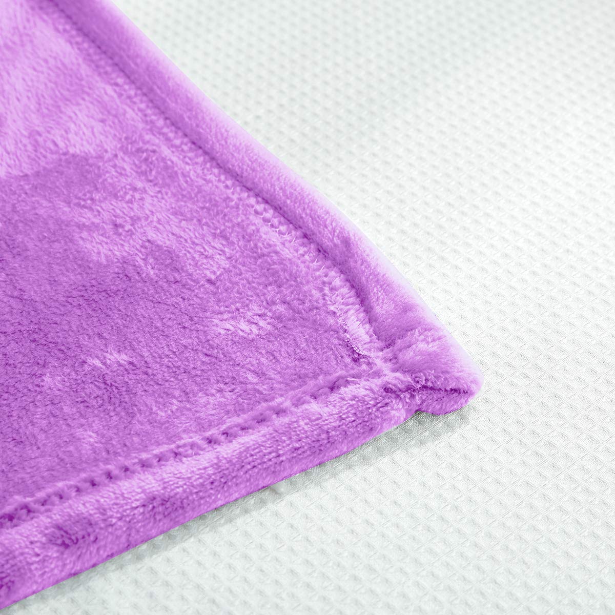 UOZZI Bedding blanket on sofa, purple, cozy warmth for family movie nights.