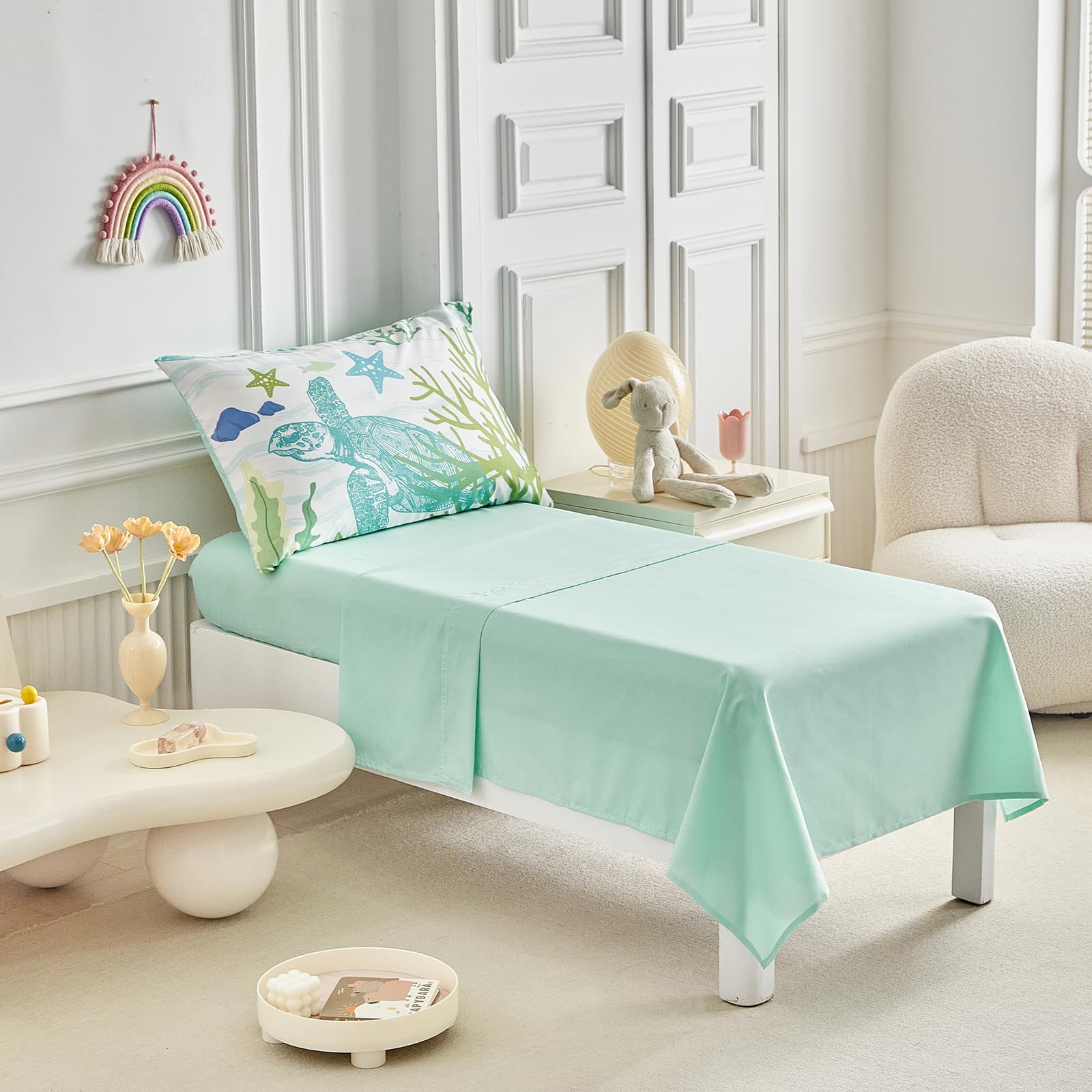 Fitted sheet in navy sea turtle set, stays snug on standard toddler beds.