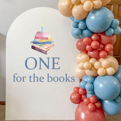 Upfirst One for Books blue arch backdrop decal enhances birthday party ambiance.