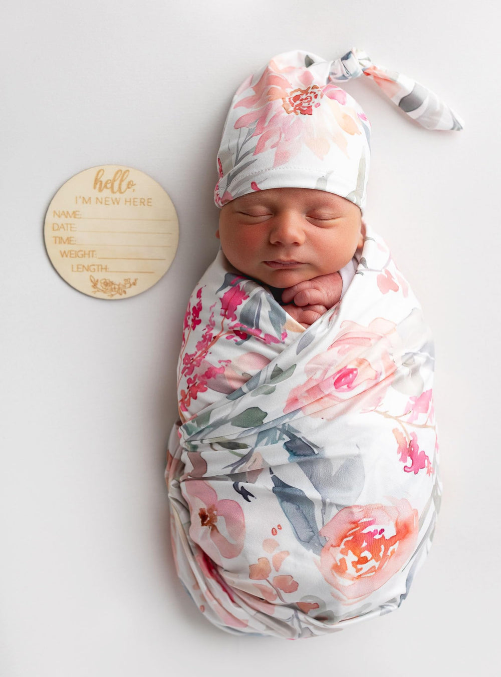 Vollmic swaddle set on a baby showing pink floral leaf pattern.