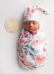Vollmic swaddle set on a baby showing pink floral leaf pattern.