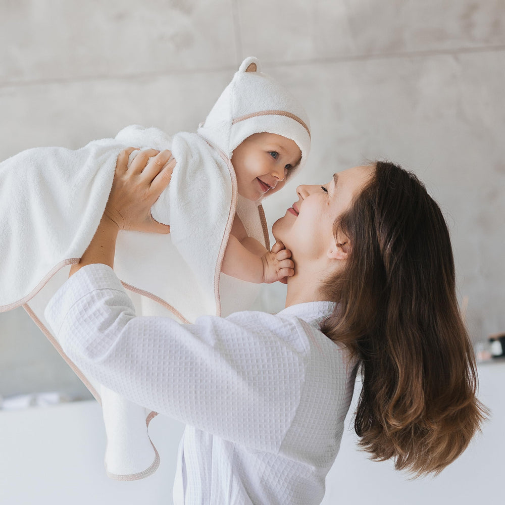 Warm Cuddles newborn hooded towel on infant illustrates cozy warmth.