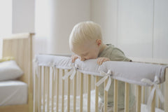 Wazzo crib rail edge cover side view demonstrates secure fit on standard rails