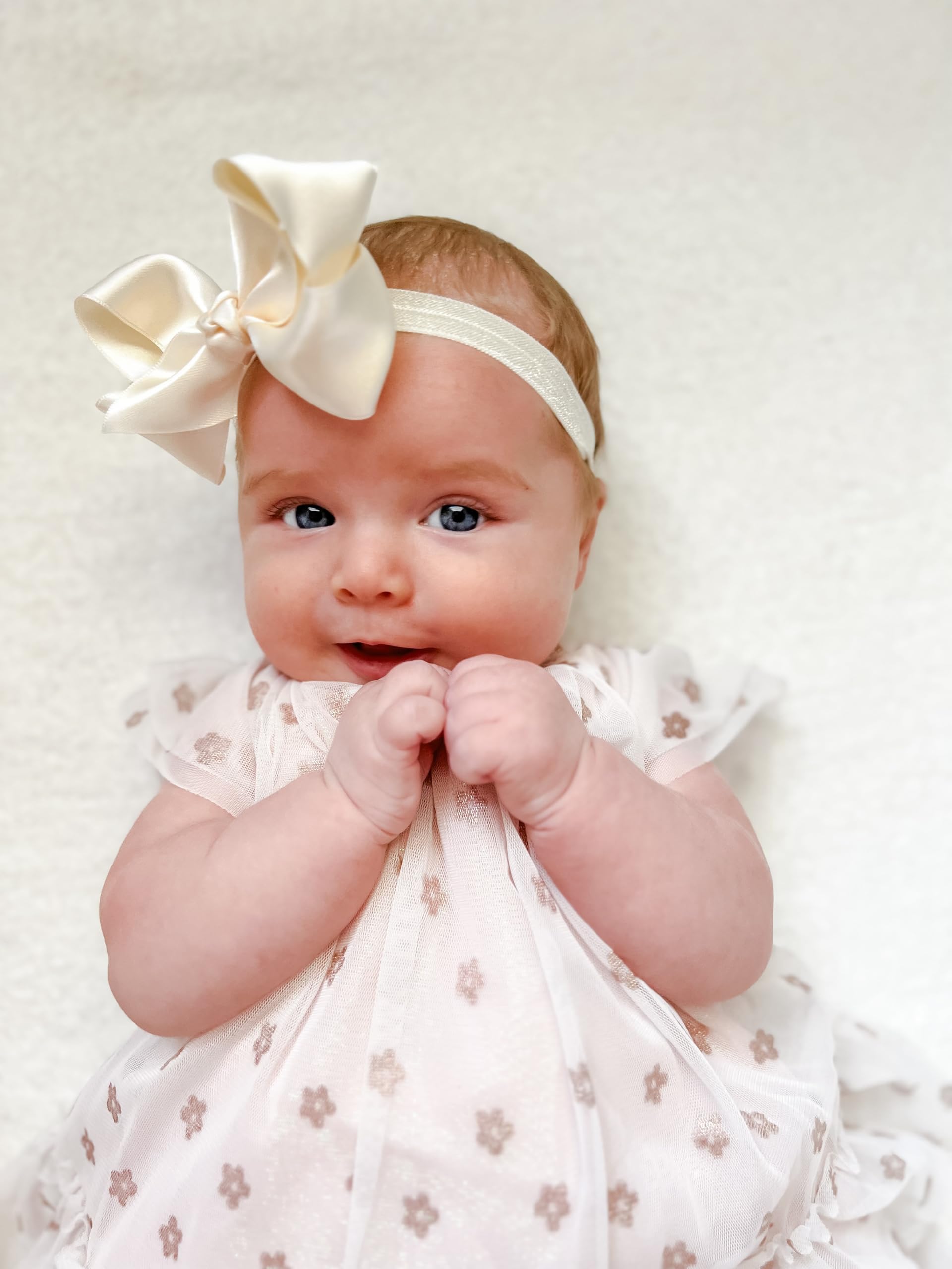 Elegant ecru satin bow complements festive outfits and portraits.
