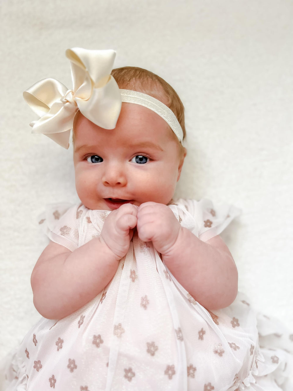 Elegant ecru satin bow complements festive outfits and portraits.