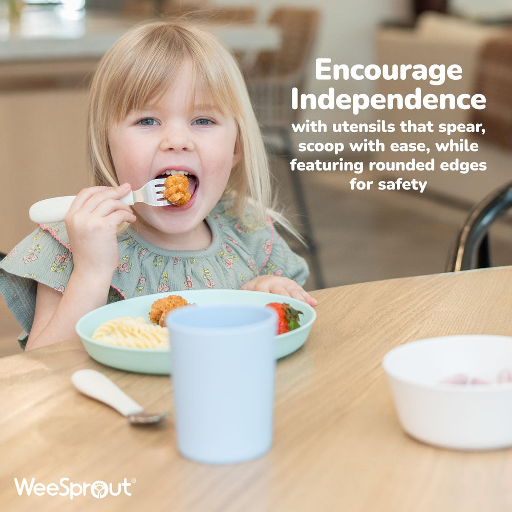WeeSprout utensils in use during self-feeding practice with a curious toddler.