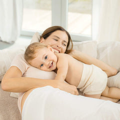 Weleda Calendula Baby Cream applying to skin during diaper change for soothing care.