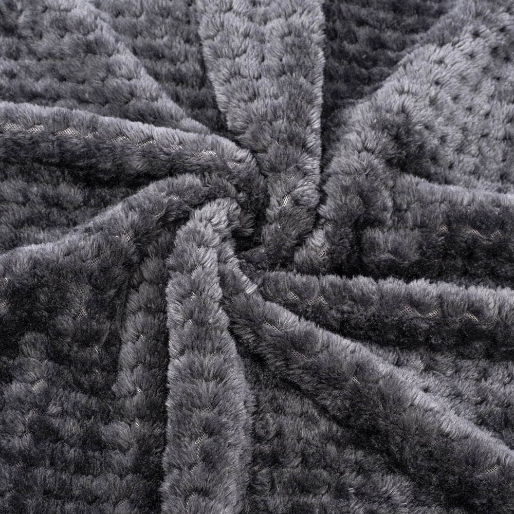 Dark grey Wonder Miracle blanket draped over a sleeping baby.