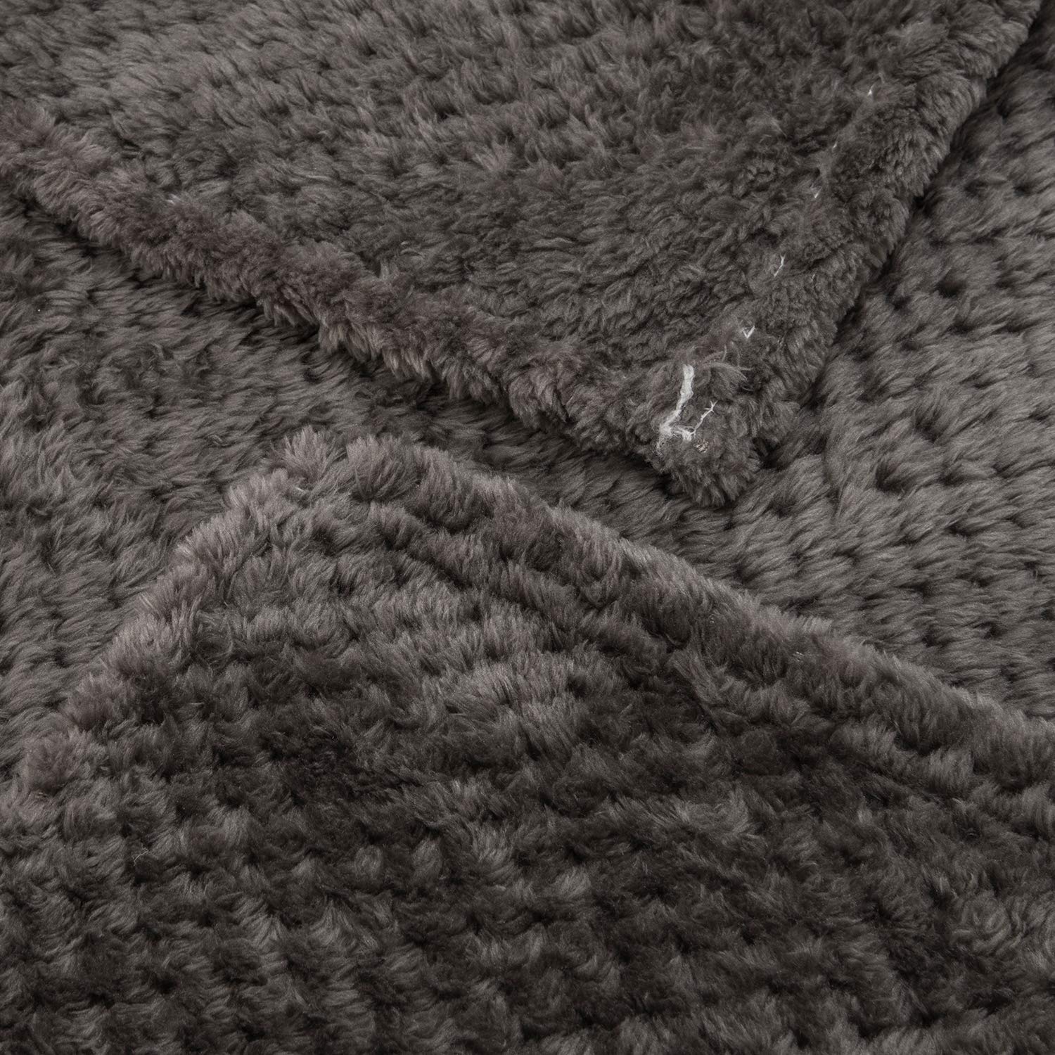 Blanket on bed and couch illustrates all-season comfort and relaxed warmth.