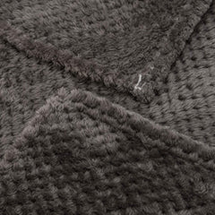 Blanket on bed and couch illustrates all-season comfort and relaxed warmth.