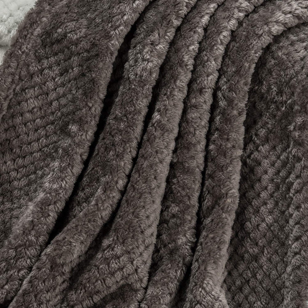 Travel-ready Wonder Miracle fuzzy throw blanket tucked in a bag for easy transport.
