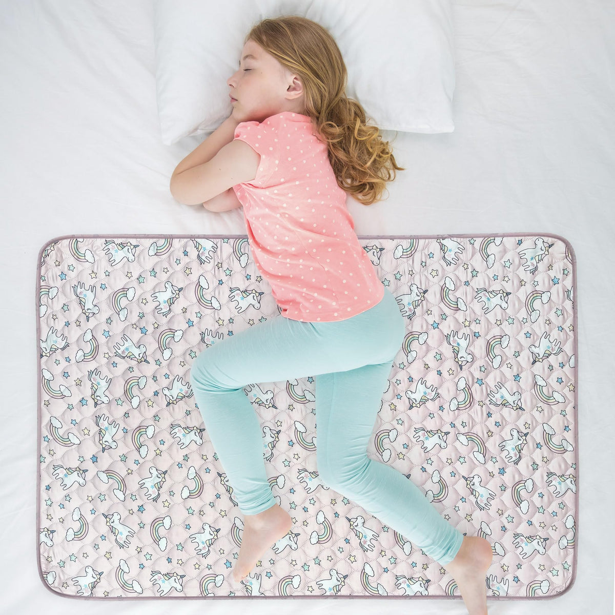 WOVENX Unicorn 34x52 bed pad laid flat on a twin mattress for overnight protection.
