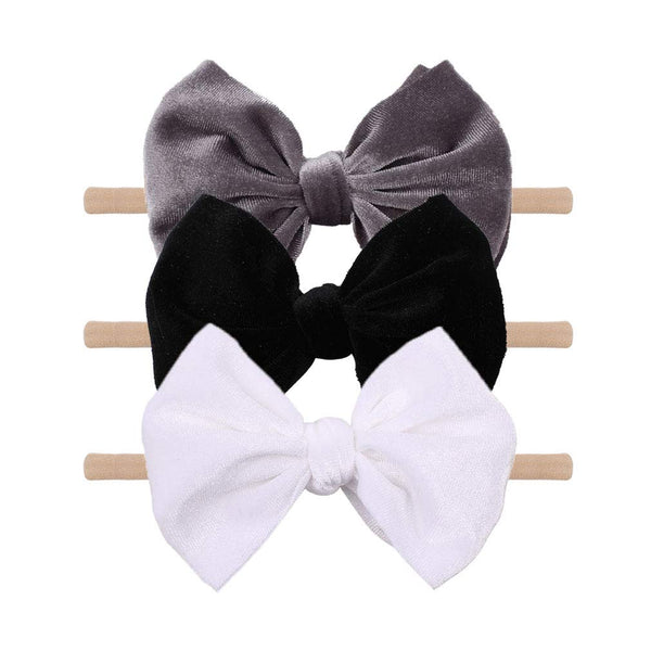 YanJie velvet bow on a black headband showing soft texture and gentle padding for newborns