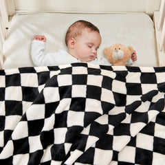 Yurhap checkered baby blanket laid out in a nursery setting
