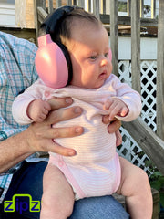 ZIPZ pink earmuffs worn by a toddler with a cute look