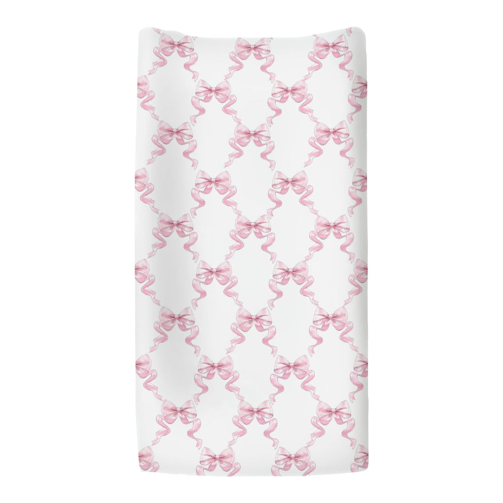 ZoUbqchY Pink Bows changing pad cover shown on a contoured pad in nursery.