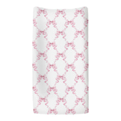 ZoUbqchY Pink Bows changing pad cover shown on a contoured pad in nursery.