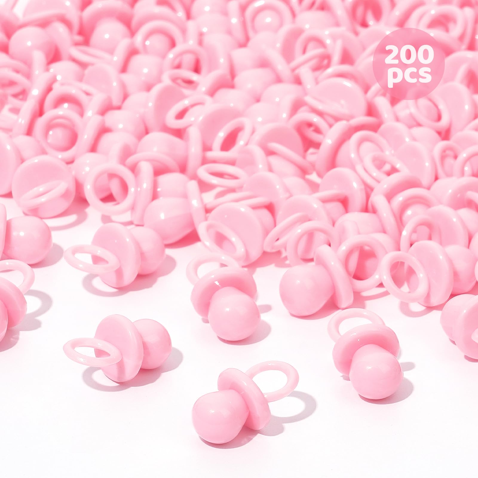 ZYFLSQ pink 200 mini pacifiers scattered on a table for baby shower decor